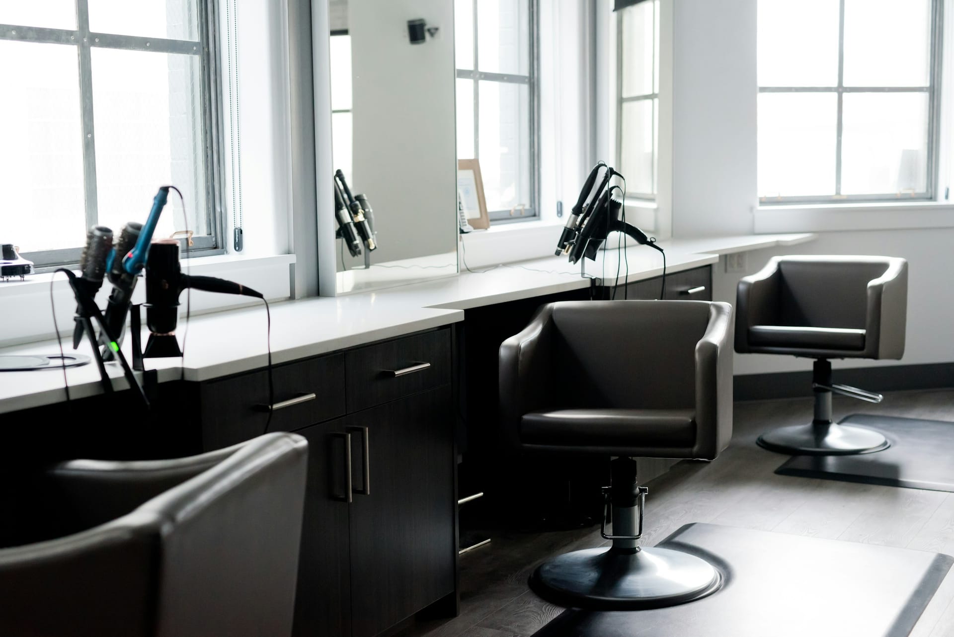 Modern barbershop interior with styling chairs and large windows